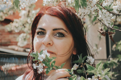 Mature woman smelling cherry flowers