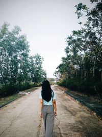 Rear view of man walking on road