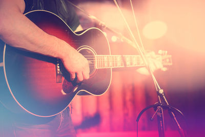 Midsection of woman playing guitar