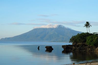 Scenic view of sea and mountains against sky