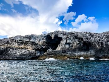 Rock formations by sea against sky