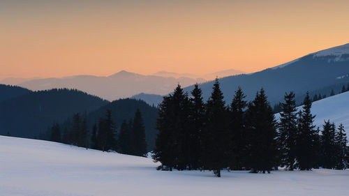 Scenic view of snowcapped mountains against sky during sunset