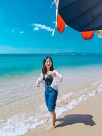 Portrait of young woman standing at beach