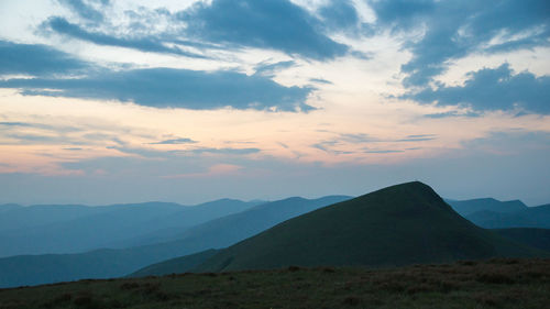 Scenic view of mountains against cloudy sky