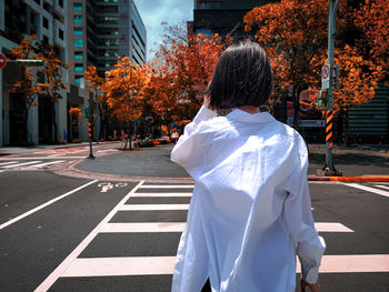 Rear view of woman walking on road