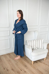 Portrait of mid adult woman in bathrobe standing on floor home