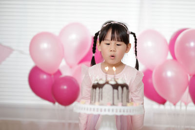 High angle view of girl with pink balloons