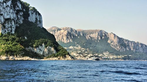 Scenic view of sea and mountains against clear sky