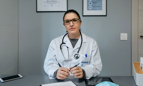 Female doctor looking at camera in her office