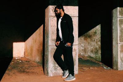 Full length of man standing against wall in building