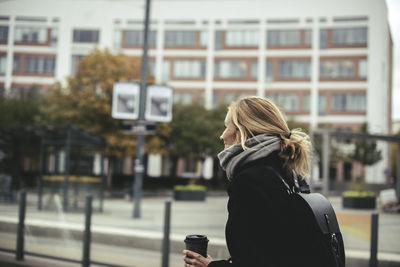 Side view of businesswoman wearing winter coat at tram station