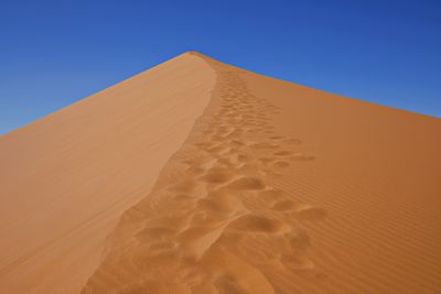 Sand dune against blue sky