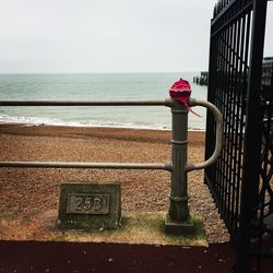 Fire hydrant by sea against sky