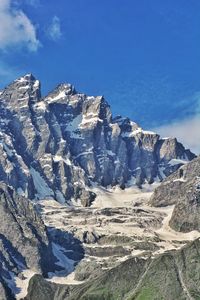 Scenic view of snowcapped mountains against blue sky