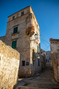 Low angle view of old building against clear blue sky