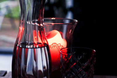 Close-up of drink in jar by lit candle at home