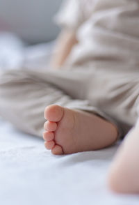 Low section of baby on bed