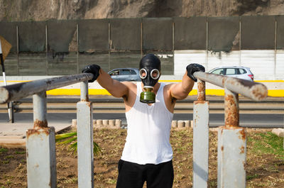 Full length of man standing by fence