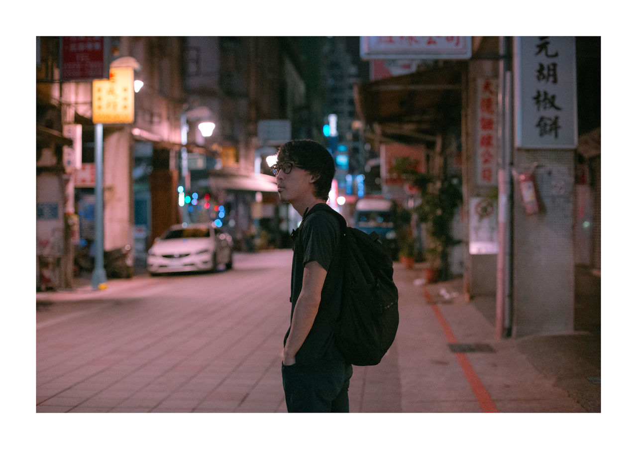 WOMAN STANDING ON STREET IN CITY