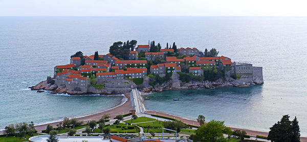 High angle view of buildings and sea against sky