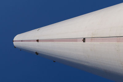 Low angle view of airplane flying against clear blue sky