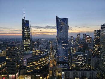 Illuminated buildings in city against sky
