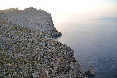 Rock formations by sea against sky