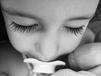 Close-up of baby girl sleeping with pacifier in mouth