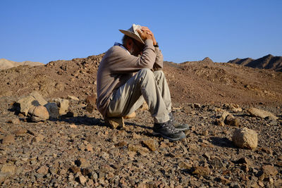 Lonely senior man sitting in the desert 