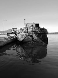 Abandoned boat moored on sea against sky