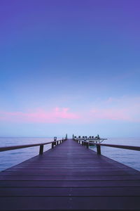 Pier over sea against sky during sunset