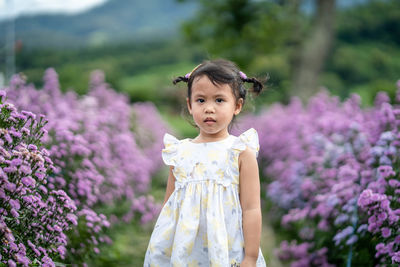 Woman standing on purple flowering plants on field