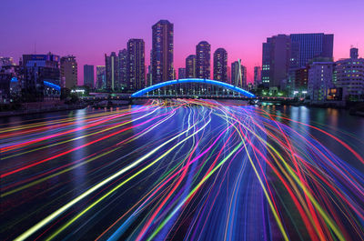 Light trails on illuminated city buildings at night