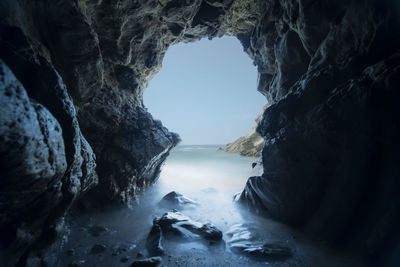 Rock formation in sea against sky