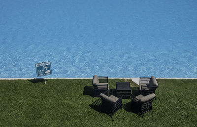 Information sign by sea against clear blue sky