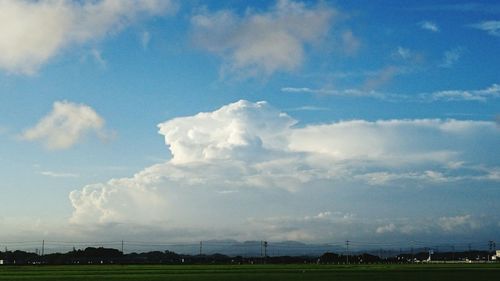 Scenic view of grassy field against cloudy sky