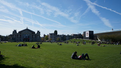 Group of people on field against buildings