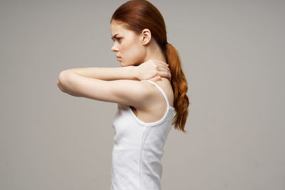 Young woman standing against white background