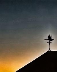 Low angle view of weather vane against sky