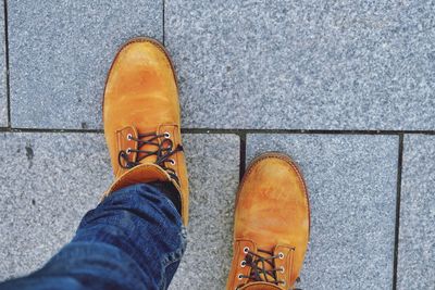 Low section of man walking on footpath at street