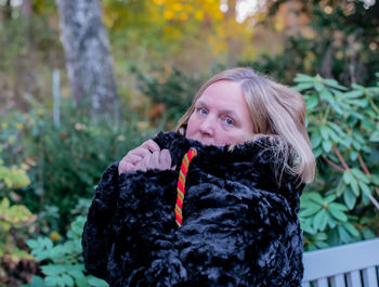 Portrait of mature woman in warm clothes standing outdoors