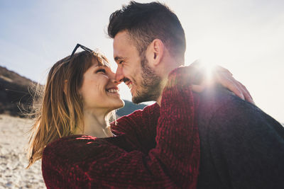 Close-up of happy couple standing against sky