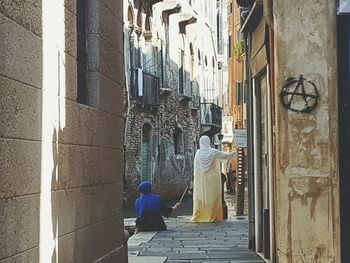 Rear view of man walking in alley