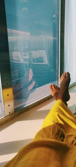 Low section of man relaxing on window