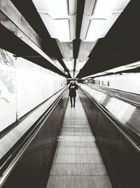 Woman walking on escalator