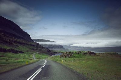 Country road against cloudy sky