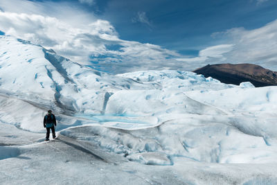 Man standing on snowcapped mountain against sky