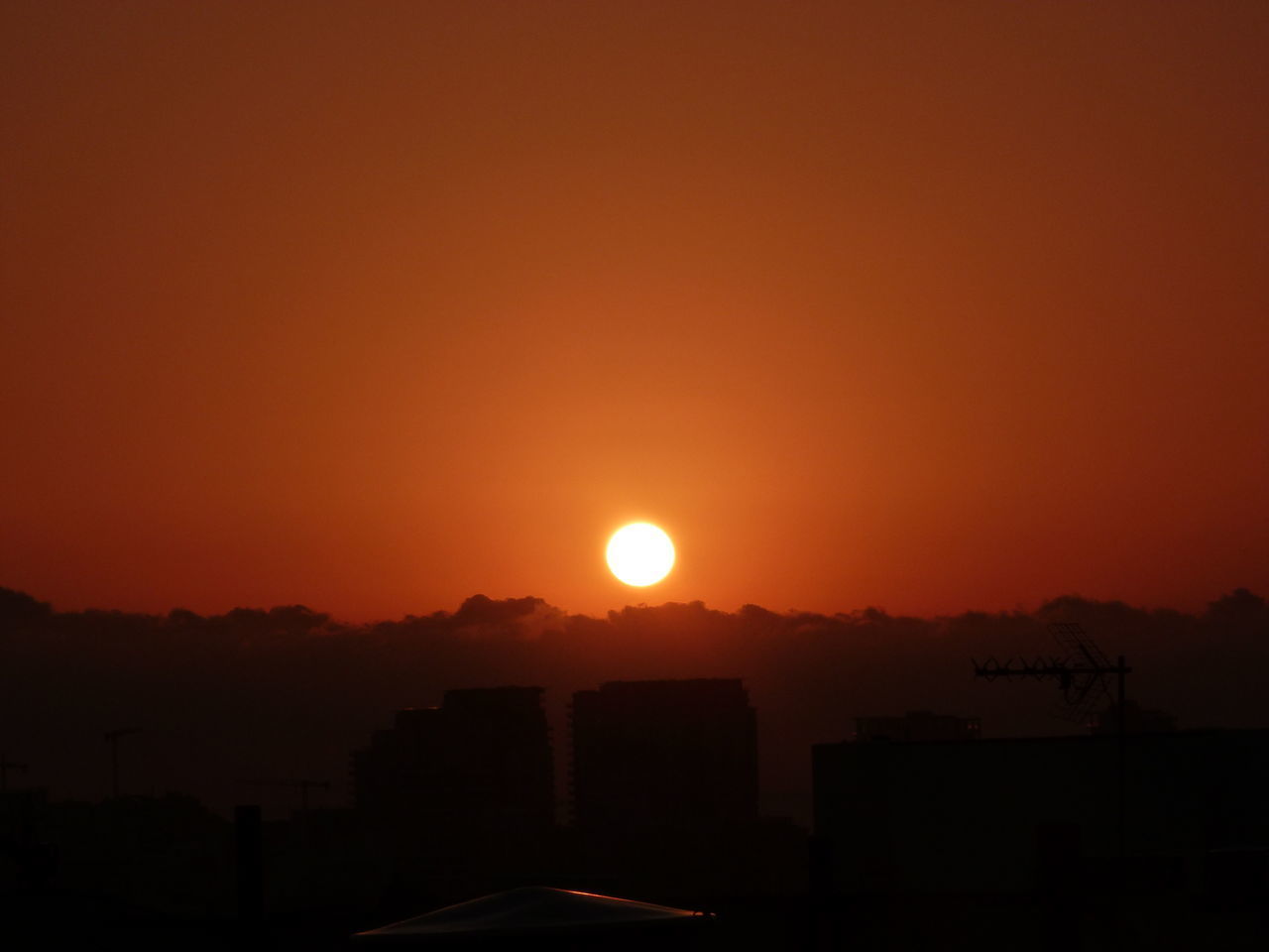 SILHOUETTE BUILDINGS AGAINST ORANGE SKY