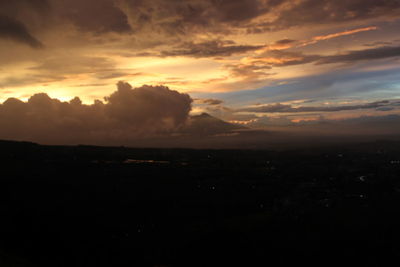 Scenic view of silhouette landscape against dramatic sky during sunset