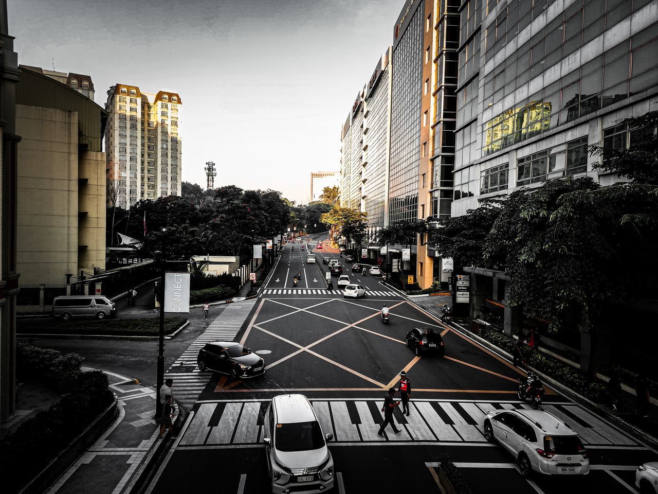 HIGH ANGLE VIEW OF VEHICLES ON ROAD BY BUILDINGS